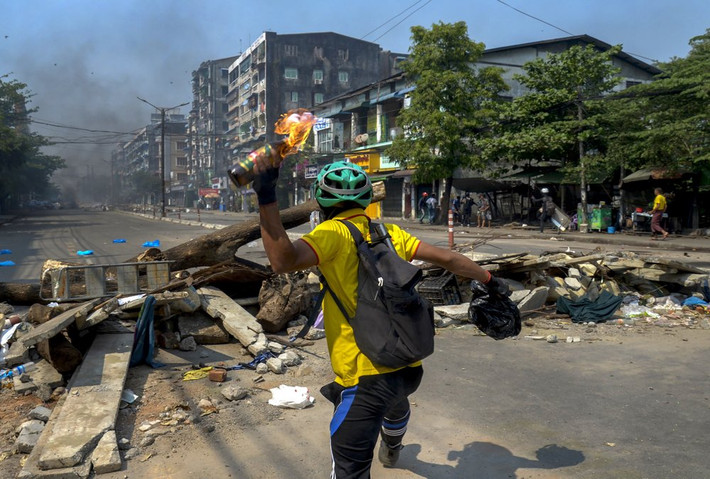 Một người biểu tình ném bom xăng về phía cảnh sát ở Yangon. Ảnh: AP.