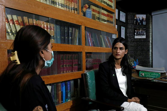 Nisha Rao, 28 tuổi, luật sư chuyển giới hành nghề đầu tiên của Pakistan, trao đổi với một khách hàng tại văn phòng ở Karachi ngày 23/11/2020