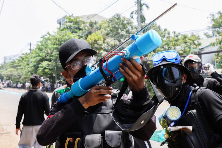 Người đàn ông cầm một "vũ khí" trong cuộc biểu tình ở Yangon, hôm 27/3. Ảnh: Reuters.
