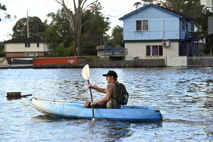 Một cư dân địa phương chèo thuyền kayak ở vùng ngoại ô Windsor hôm 24/3. Ảnh: Reuters.