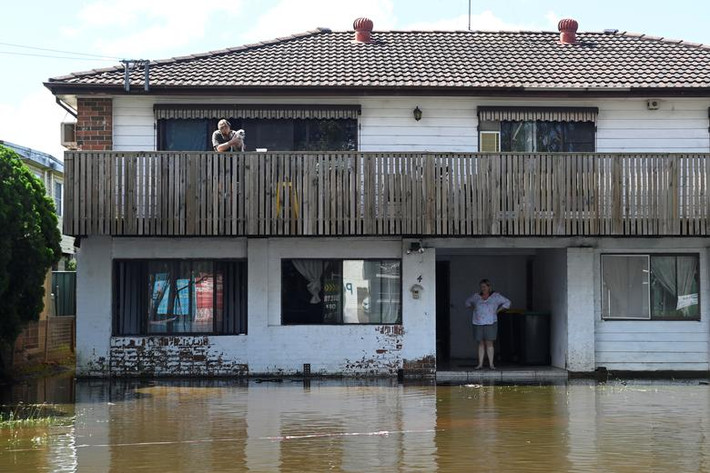 Brant và Deann đứng trong ngôi nhà bị nước lũ "bao vây" gần Sydney, Australia, ngày 24/3. Ảnh: Reuters.