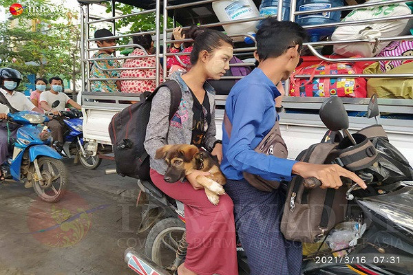 Một số người chở thú cưng trên xe máy trong khi những người khác gói ghém đồ đạc vào túi chất lên xe tuk-tuk. Ảnh: Irrawaddy.