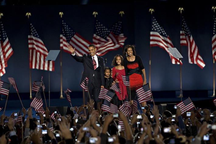 Tổng thống đắc cử Barack Obama đứng trên khán đài cùng vợ, Michelle Obama, và hai con gái, vẫy tay chào những người ủng hộ ở Chicago ngày 4/11/2008.