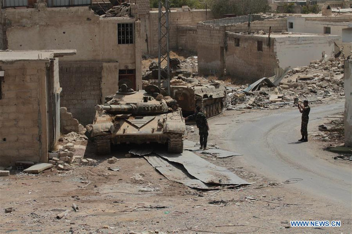 Một binh sĩ Syria chụp ảnh trước chiếc xe tăng trong thị trấn Daraya hôm 26/8. Ảnh: THX.