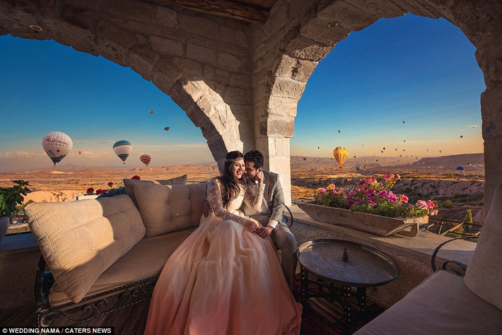 Những quả khinh khí cầu đầy màu sắc trên bầu trời Cappadocia ở Thổ Nhĩ Kỳ làm nền cho cặp cô dâu chú rể.