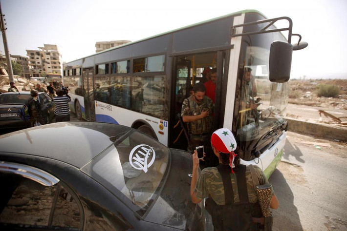 Người dân chuẩn bị lên xe buýt rời khỏi thị trấn Daraya. Ảnh: Reuters.