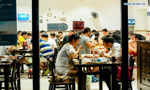 Cuộc sống thường nhật của người dân thành phố Hàng Châu, tỉnh Chiết Giang, được tái hiện qua bộ ảnh mới nhất của Tân Hoa Xã. Ảnh: Người dân ăn tối tại một cửa hàng ở quận Tân Giang, Hàng Châu, hôm 26/8.