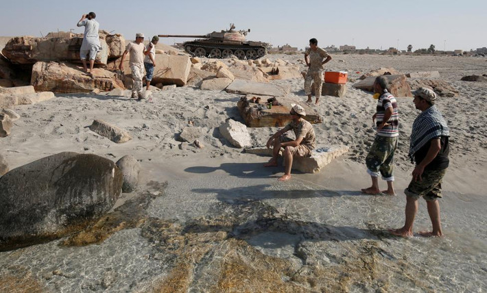 Các chiến binh lực lượng Libya ngồi nghỉ trên bờ biển trước khi giao chiến.