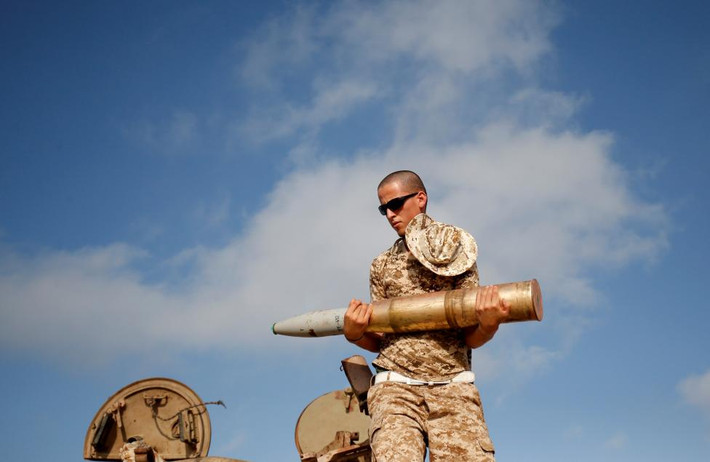 Một chiến binh lực lượng Libya mang khẩu pháo đứng trên xe tăng T-55 do Liên Xô sản xuất.