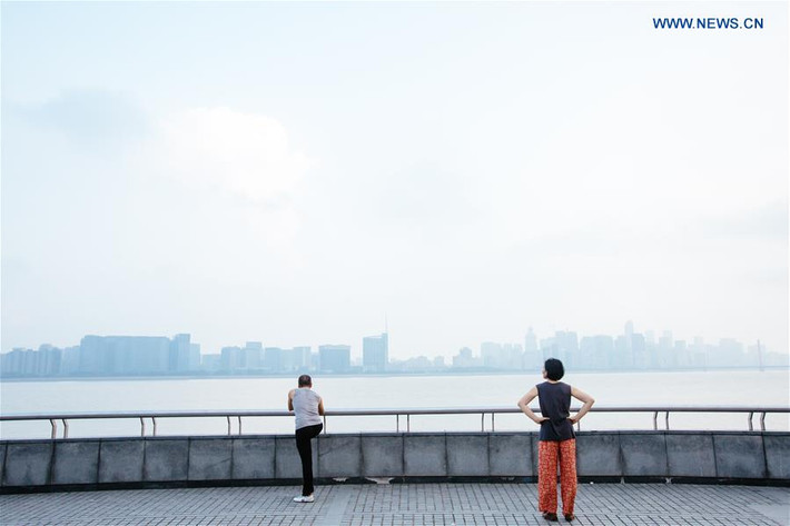 Người dân tập thể dục buổi sáng bên bờ sông Tiền Đường.