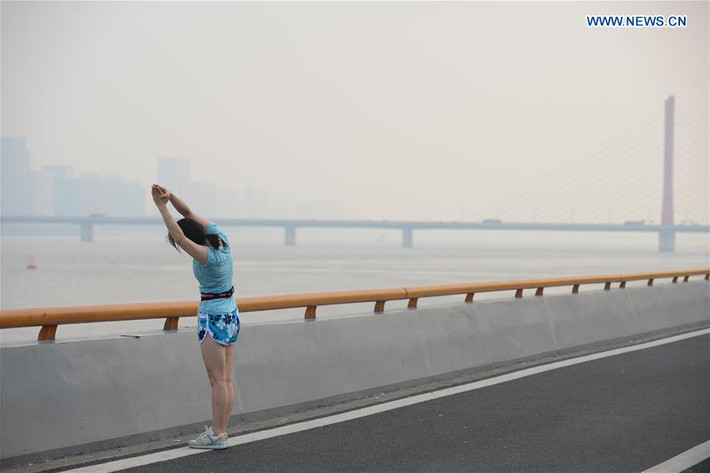 Một cô gái tập yoga bên bờ sông Tiền Đường ở thành phố Hàng Châu hôm 26/8.