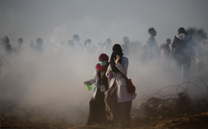 Các bác sĩ Palestine đi ra khỏi khu vực hỗn loạn ở Dải Gaza ngày 12/10. Ảnh: Reuters.