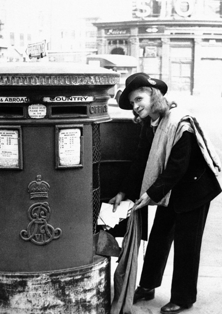 Một nữ nhân viên bưu chính đang lấy thư từ hòm thư ở London, Anh, ngày 30/11/1942.