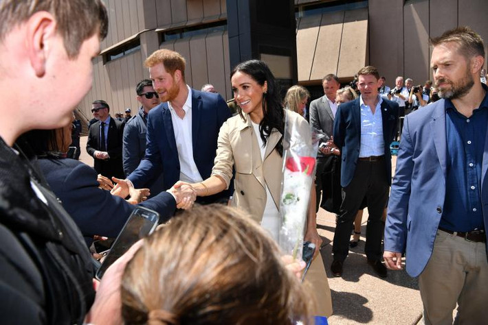Hoàng tử Anh Harry và Công nương Meghan Markle bắt tay mọi người khi tới thăm nhà hát Opera ở Sydney.
