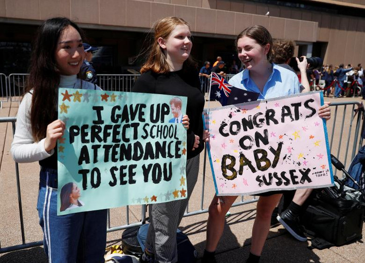 Nhiều cô gái cầm poster chào đón Hoàng tử Harry và Công nương Meghan Markle.