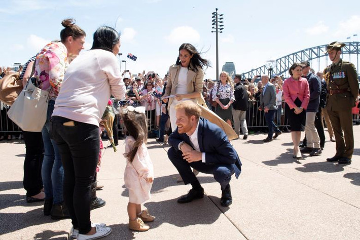 Vợ chồng Hoàng tử Harry trò chuyện với một em nhỏ khi tới thăm nhà hát Opera tại Sydney, Australia, ngày 16/10.
