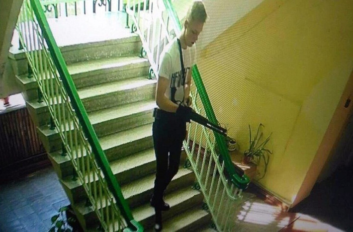 Hình ảnh từ camera an ninh tại trường Cao đẳng Bách khoa Kerch cho thấy trước khi thực hiện vụ tấn công, nghi phạm Roslyakov bình tĩnh đi cầu thang bộ của trường, đeo găng tay và cầm súng. Ảnh: Meduza.