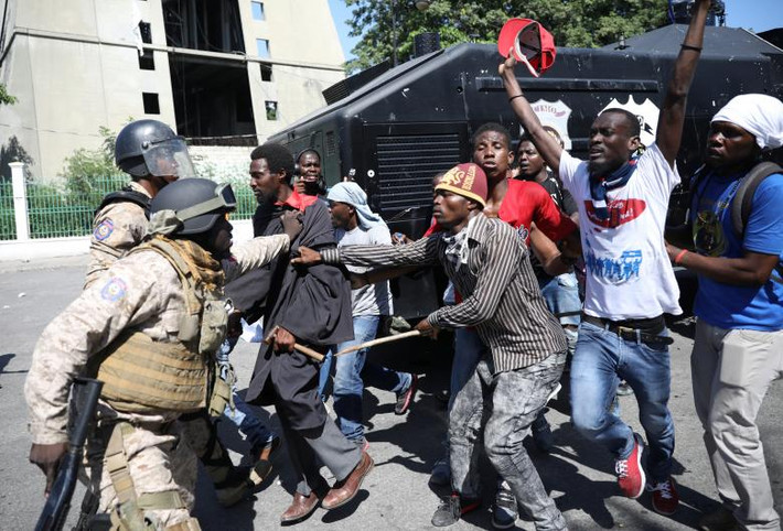 Cảnh sát Haiti ngăn một người biểu tình quá khích trong cuộc tuần hành ở thủ đô Port-au-Prince.