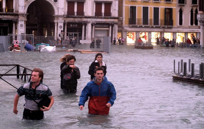 Người dân lội qua khu vực Quảng trường Saint Mark ngập lụt ở Venice ngày 29/10. Ảnh: Reuters.