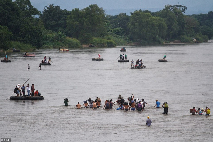 Hàng chục di dân Honduras băng qua sông Suchiate, ranh giới tự nhiên giữa Guatemala và Mexico. Ảnh: EPA.