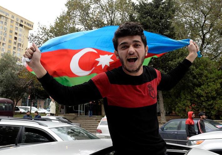 Một thanh niên mang theo cờ ở Baku hôm 8/11. Ảnh: Reuters.