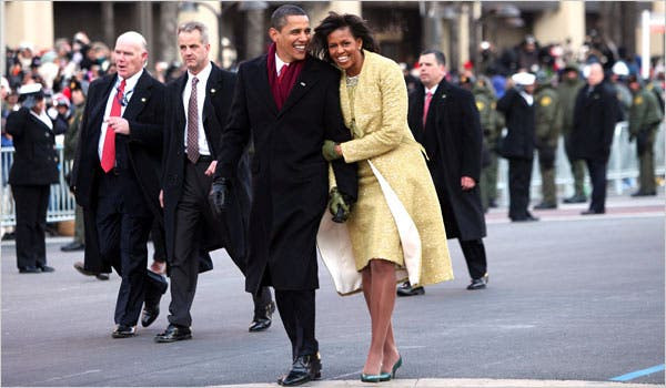 Tổng thống Obama cùng vợ đi bộ từ Điện Capitol về Nhà Trắng trong tiếng chào mừng của người dân hai bên đường. Ảnh: NYT.