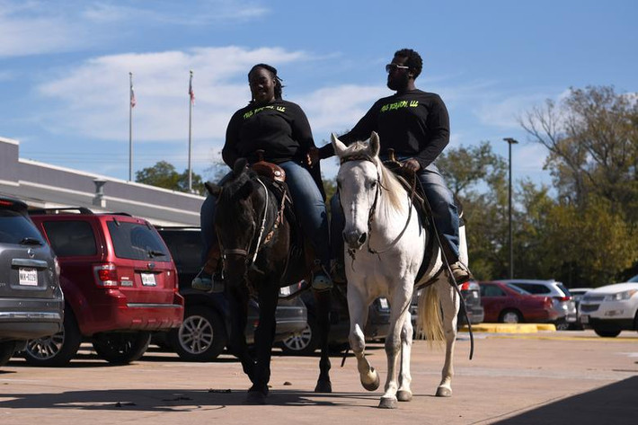 Hình ảnh Eboni Price và Cornelius Ates cưỡi ngựa đi bỏ phiếu ở Houston, bang Texas.