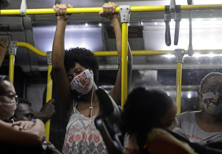 Hành khách đeo khẩu trang khi đi trên xe buýt công cộng ở Rio de Janeiro ngày 29/4.