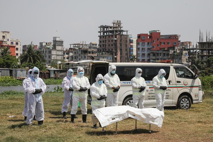 Mọi người cầu nguyện cho một người đàn ông chết vì nhiễm virus corona, trước khi chôn cất nạn nhân tại nghĩa trang ở Dhaka, Bangladesh, hôm 6/4.