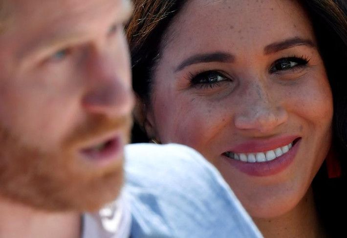 Công nương Meghan đứng bên cạnh khi Hoàng tử Harry phát biểu trong chuyến thăm thị trấn Tembisa, gần Johannesburg, Nam Phi, ngày 2/10/2019.