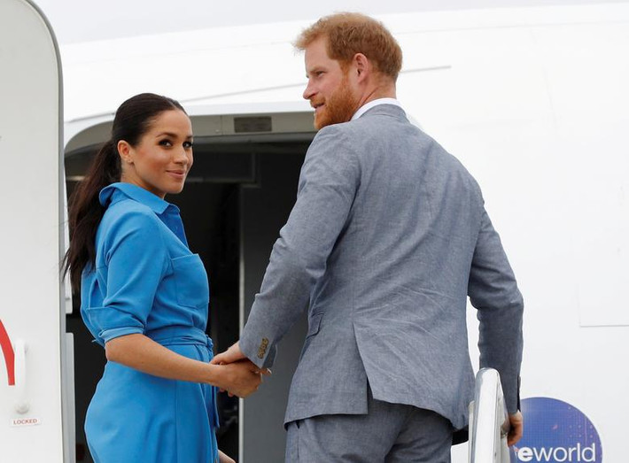 Vợ chồng Hoàng tử Harry nắm nay nhau khi lên máy bay tại sân bay quốc tế Fua'amotu ở Tonga ngày 26/10/2018.