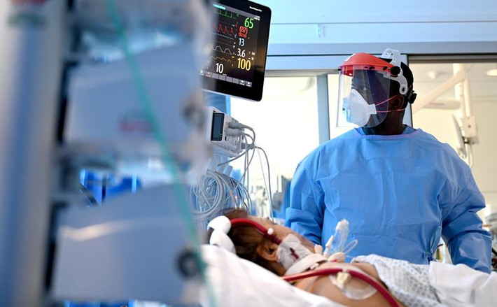 Bác sĩ kiểm tra sức khỏe cho một bệnh nhân COVID-19 đang nằm điều trị trong phòng chăm sóc tích cực tại bệnh viện Royal Papworth ngày 5/5.
