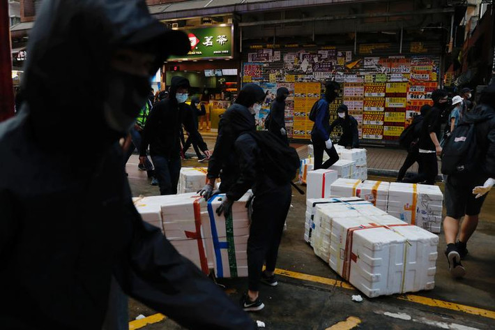 Những người biểu tình đeo khẩu trang dựng "chướng ngại vật" trên đường phố ở Mong Kok hôm 10/5.