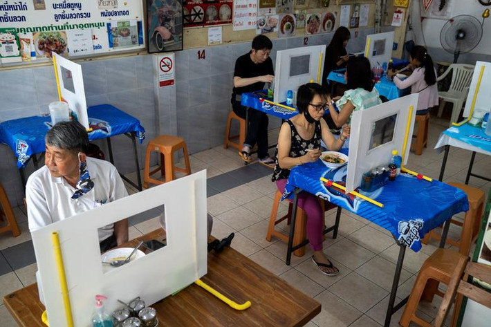 Các thực khách ăn trưa tại một nhà hàng mới được mở cửa trở lại ở Bangkok, Thái Lan.