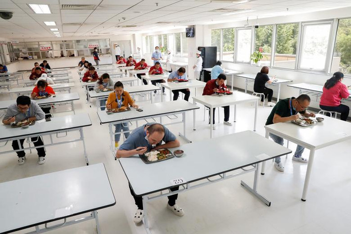 Các nhân viên ngồi cách xa nhau trong phòng ăn của một công ty ở Bắc Kinh, Trung Quốc, ngày 14/5.