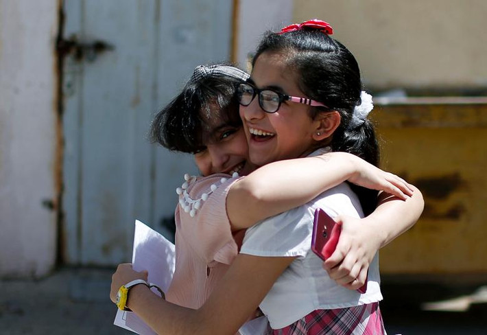 Hai em học sinh Palestine vui mừng sau khi nhận chứng nhận tốt nghiệp ở trường al-Qahera, thành phố Gaza, ngày 21/5.
