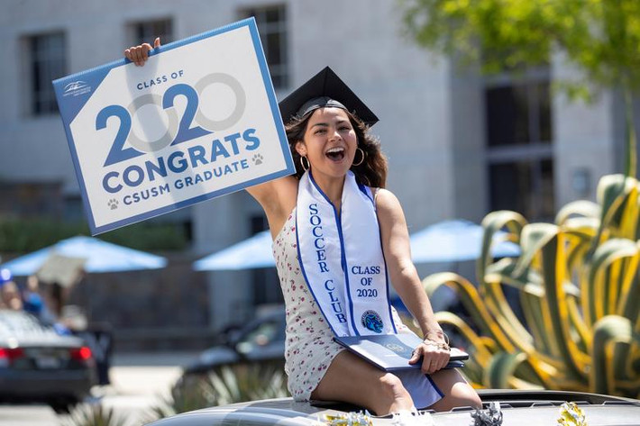 Một sinh viên tốt nghiệp của trường Đại học bang California tham gia cuộc diễu hành xe hơi qua khuôn viên trường ở San Marcos, California, (Mỹ) ngày 15/5.