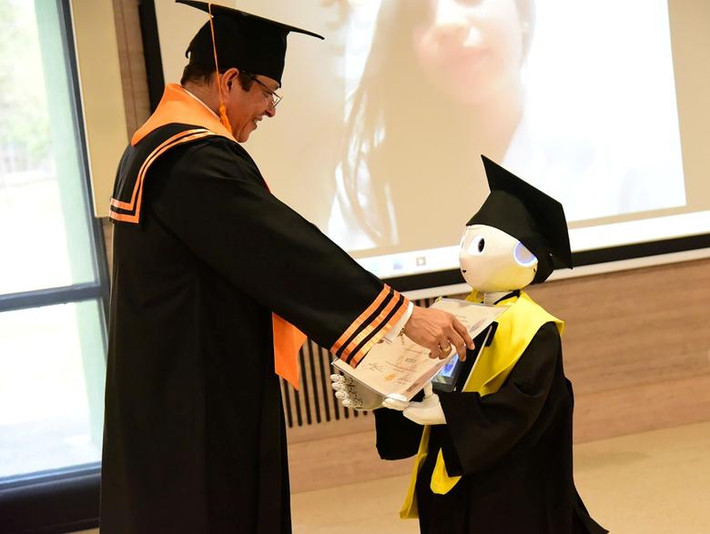 Hiệu trưởng trường Đại học Magdalena, Pablo Guerra, trao bằng của các sinh viên y khoa tốt nghiệp cho "người đại diện" là robot Lied trong lễ tốt nghiệp trực tuyến tại Santa Marta, Colombia, ngày 16/4.