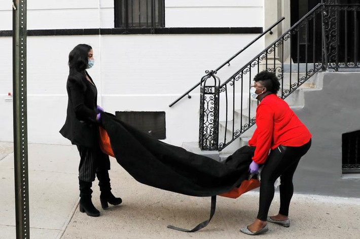 Alisha Narvaez, 36 tuổi, và Nicole Warring, 33 tuổi, làm việc tại một nhà tang lễ ở Harlem, khiêng thi thể người tử vong vì COVID-19 xuống tầng hầm, nơi lưu giữ các thi thể chờ làm tang lễ, tại Manhattan, New York, Mỹ, ngày 2/4.