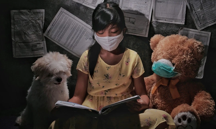 Bé gái đeo khẩu trang đọc sách tại Indonesia trong thời gian "ở nhà" tránh dịch COVID-19.