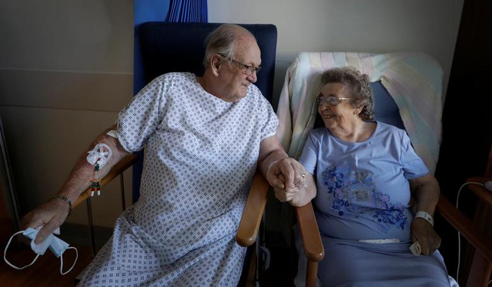 Bệnh nhân COVID-19 George Gilbert, 85 tuổi, và vợ Domneva Gilbert, 84 tuổi, mỉm cười khi được gặp nhau tại bệnh viện Addenbrooke ở Cambridge, Anh, ngày 21/5/2020.