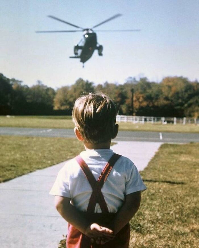 Trong ảnh, John F. Kennedy Jr., đứng chờ chiếc máy bay chở cha cậu, Tổng thống Mỹ John F. Kennedy, hạ cánh tại Trại David, Maryland, tháng 10/1963. Một tháng sau đó, vào ngày 22/11/1963, Tổng thống Kennedy bị ám sát.