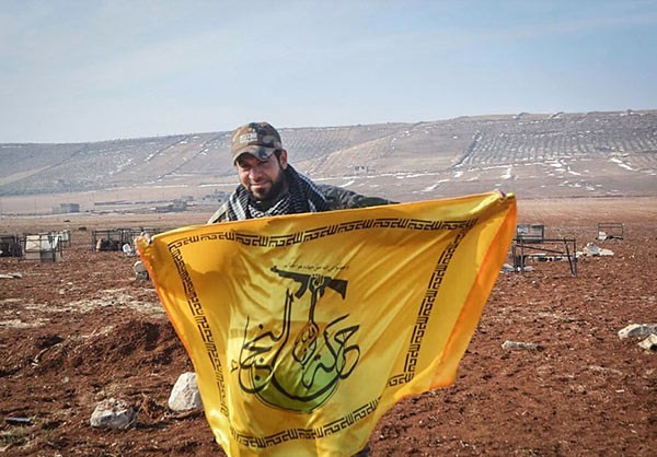 Một chiến binh của phong trào Hezbollah al-Nujaba cầm cờ của tổ chức này.