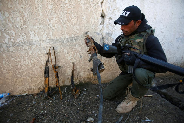Binh sĩ Iraq kiểm tra vũ khí bị nhóm IS bỏ lại trên chiến trường Mosul.