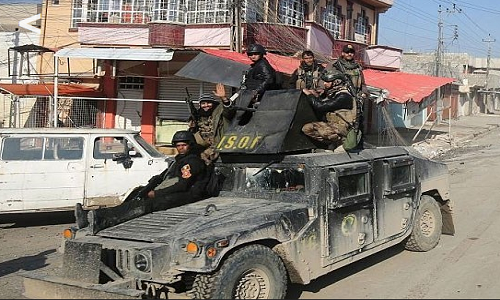 Thành viên lực lượng Iraq hào hứng khi đi qua một con đường ở Nineveh.