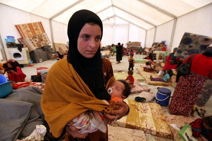 Người phụ nữ bế con trong khu trại tị nạn ở khu Makhmour, gần thành phố Mosul, Iraq, ngày 15/6/2016.