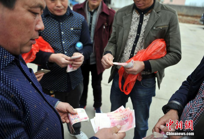 Chủ doanh nghiệp phát tiền cho các nông dân.