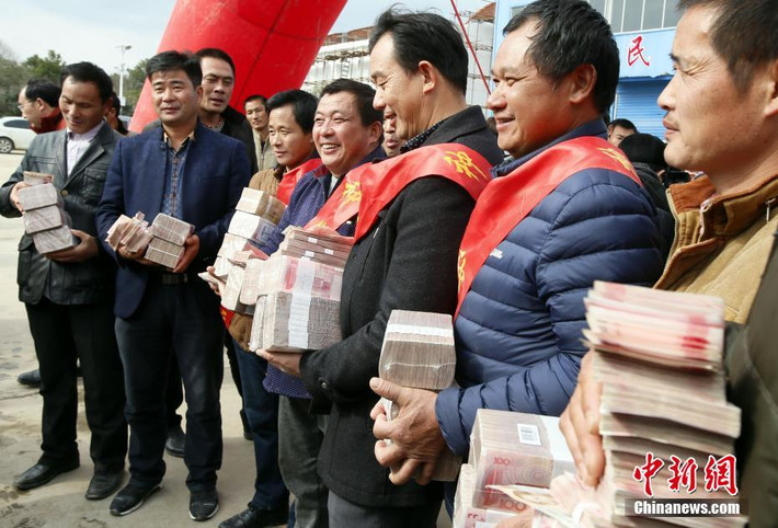 Các nông dân nhận tiền thưởng Tết ở thành phố Nam Xương, tỉnh Giang Tây.