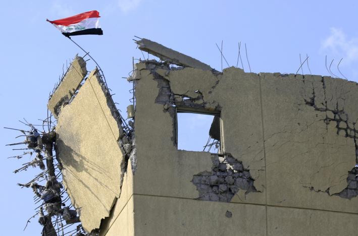 Lá cờ Iraq tung bay trên tòa nhà bệnh viện bị hư hại ở Wahda.