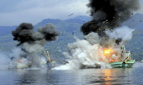 Hải quân Indonesia đánh chìm hai tàu cá nước ngoài được đăng ký tại Papua New Guinea sau khi bắt giữ những tàu cá này với cáo buộc đánh bắt cá trái phép ở vùng biển ngoài khơi Ambon, Maluku, ngày 21/12/2014.